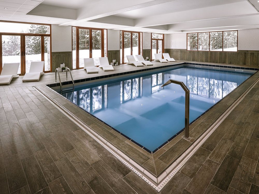La piscine intérieure du Pic Blanc, sa rampe d'accès et ses grandes baies sur les sapins enneigés