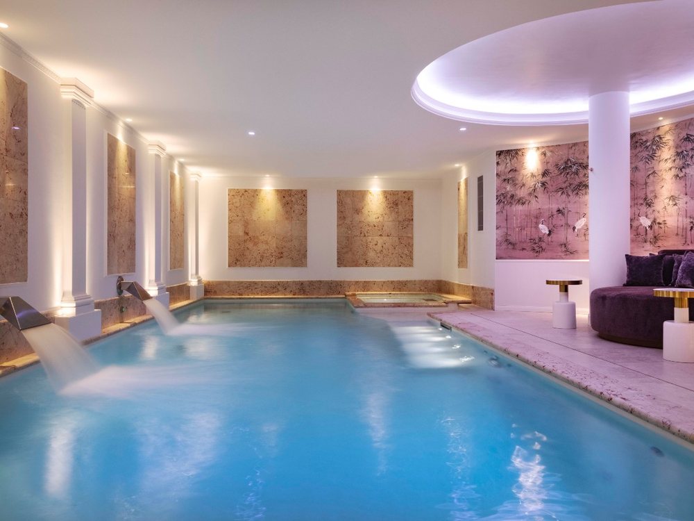 La piscine chauffée de onze mètres du spa de Paris j'Adore, entre ses colonnes et sa lumière rose