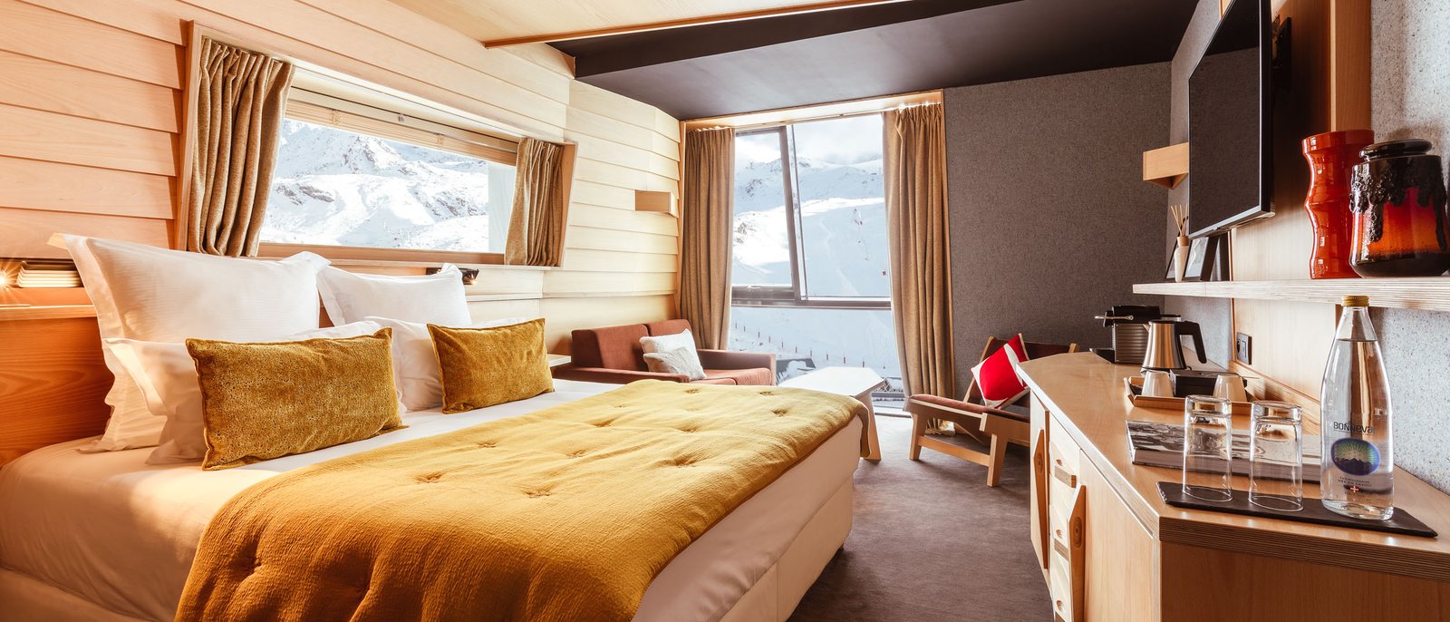 Une chambre de l'Altapura, son lit au plaid moutarde, ses murs de bois clair et sa fenêtre sur les pistes enneigées