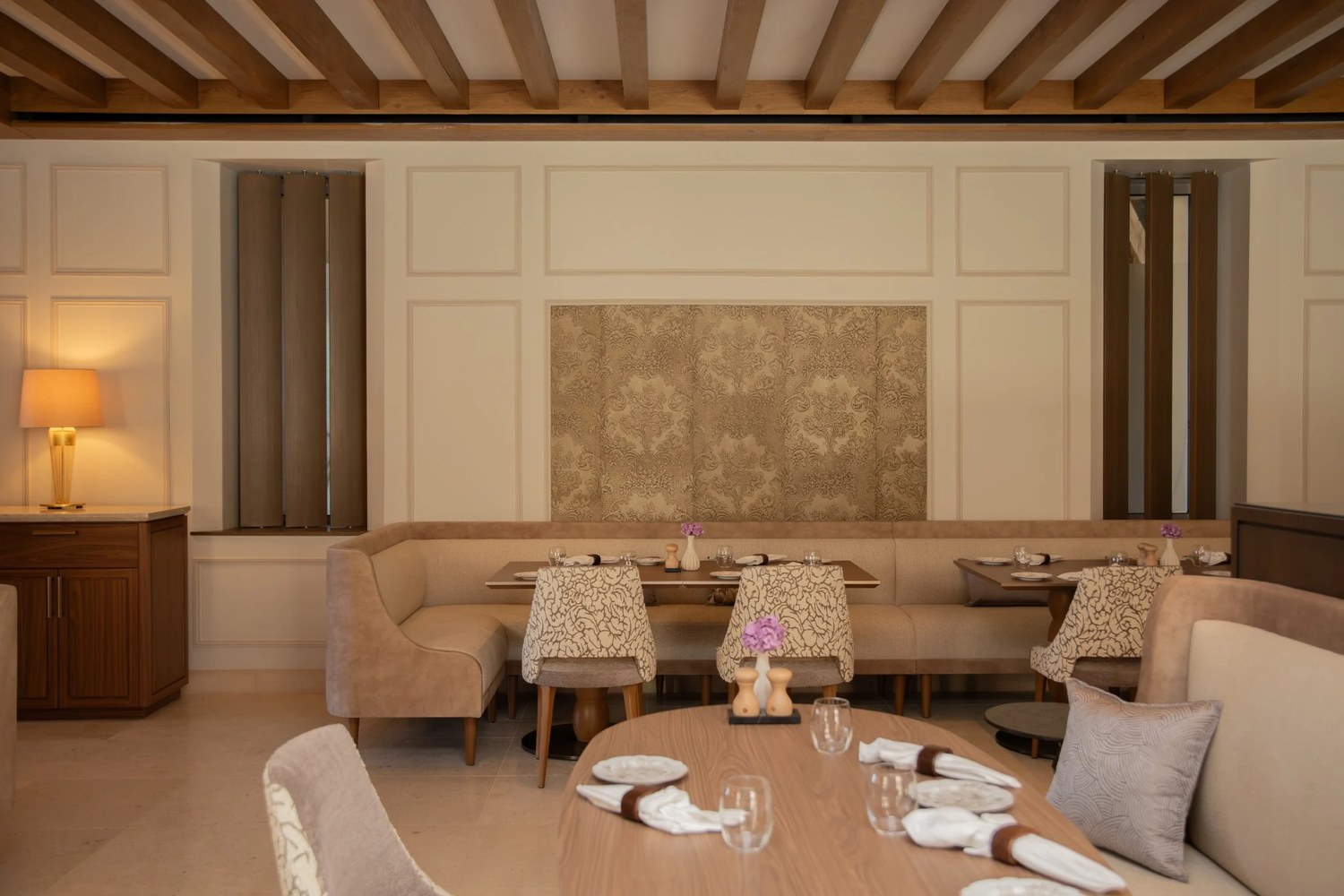 La salle du restaurant Le Clos au Château la Commaraine, poutres apparentes et boiseries claires