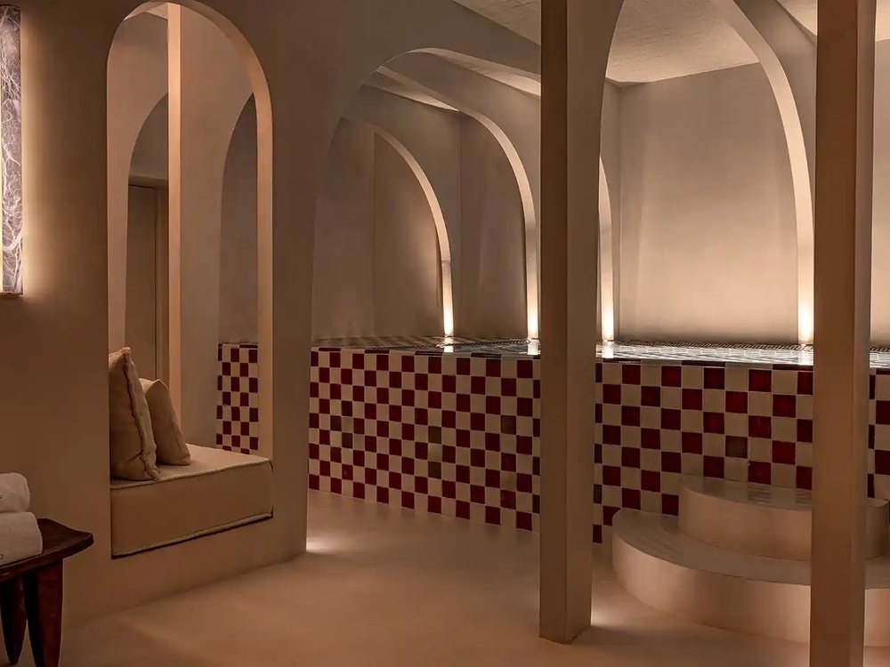 Le spa du Château des Fleurs, ses arches claires, sa banquette et son bassin bordé de carreaux bordeaux