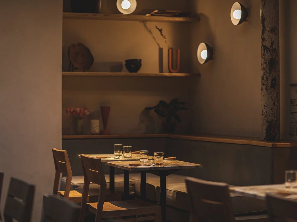 La salle de Mesa, le bar-restaurant de HOY, ses tables de bois, ses étagères et sa lumière tamisée
