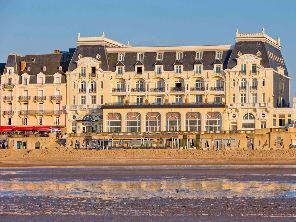 La façade Belle Époque du Grand Hôtel de Cabourg vue depuis la plage, au soleil couchant