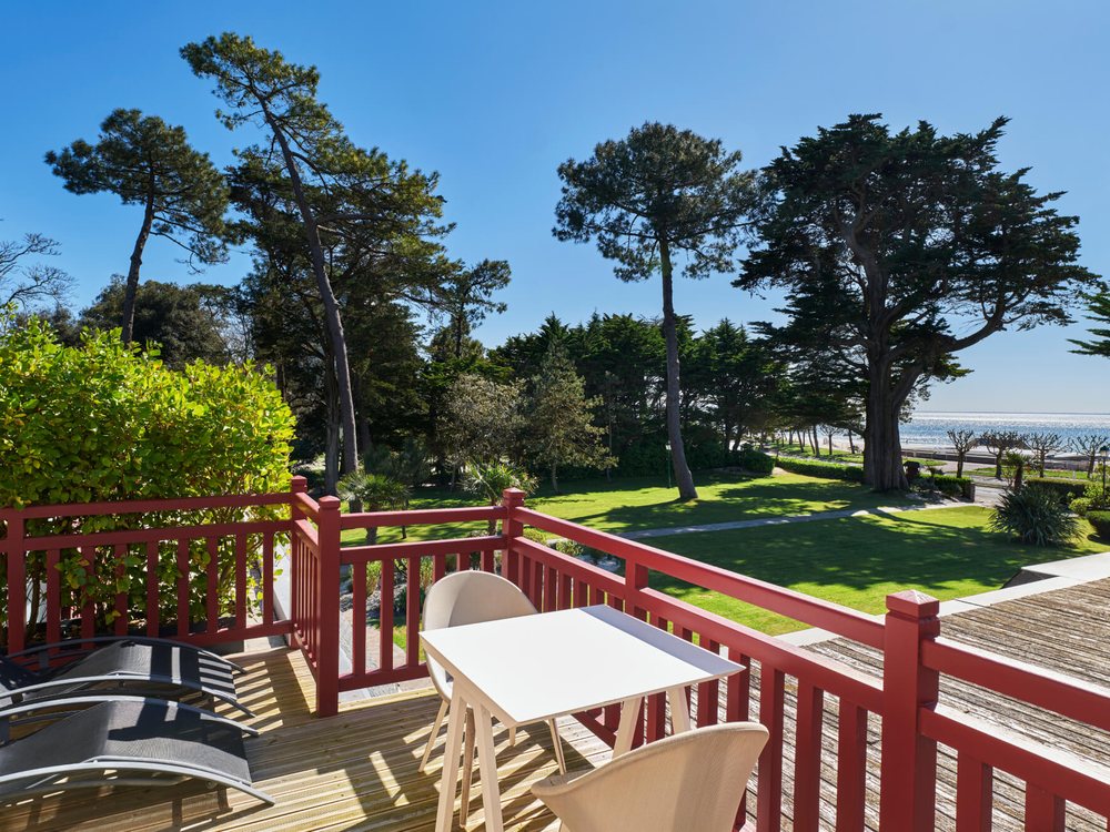 La terrasse du Castel Marie-Louise et ses garde-corps rouges, le parc, les pins et l'océan en fond