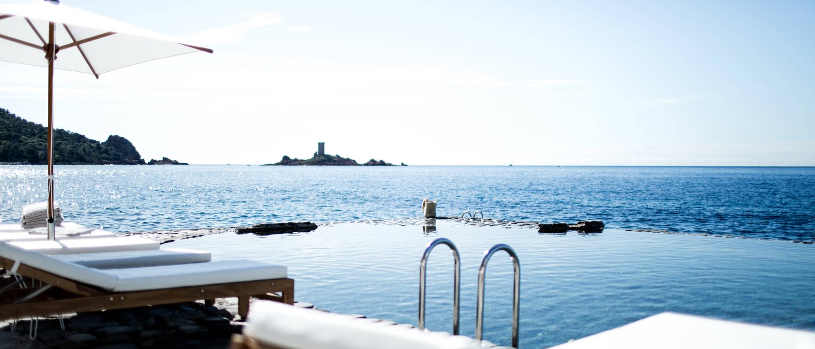 La piscine d'eau de mer des Roches Rouges taillée dans la roche, au ras de la Méditerranée, face à l'île d'Or et aux roches rouges de l'Esterel