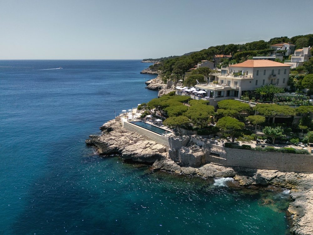 Les Roches Blanches vues du ciel, l'hôtel et ses terrasses sur les rochers au bord de la mer, à Cassis
