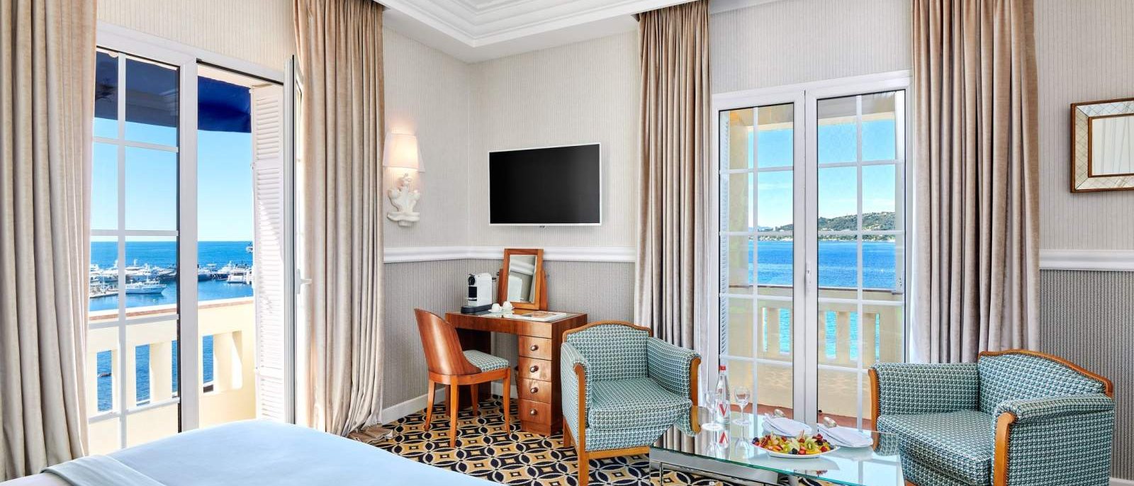 Une chambre Panoramique Mer de l'Hôtel Belles Rives, ses fenêtres ouvertes sur la baie et son tapis à motifs