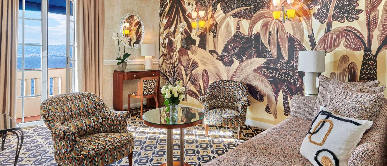 Le salon d'une suite du Belles Rives, son décor végétal peint et ses fauteuils graphiques