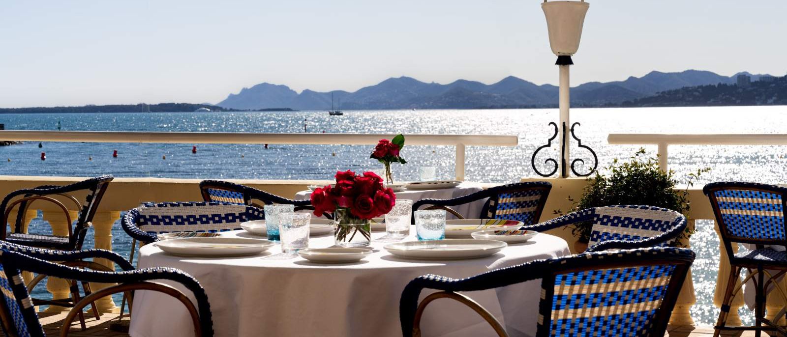 Une table dressée sur la terrasse du Belles Rives, face à la baie de Juan-les-Pins et à l'Estérel