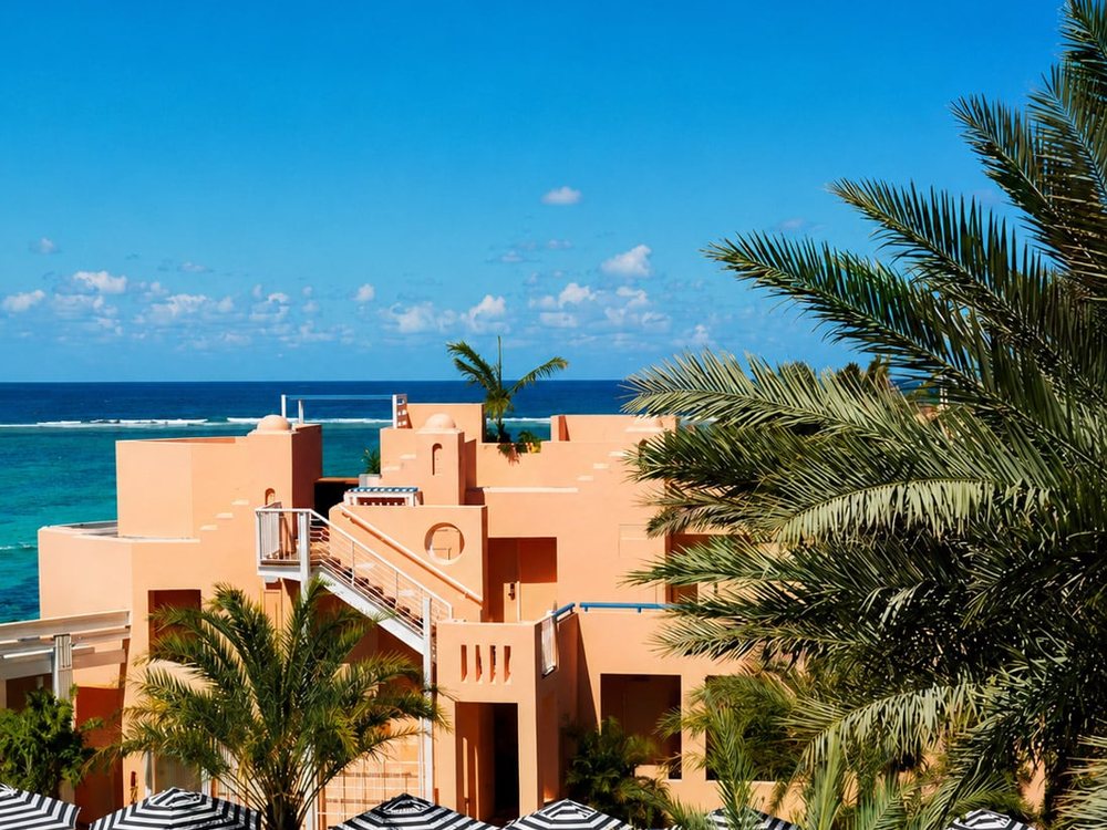 Les façades roses de SALT of Palmar, sa piscine et ses palmiers face à l'océan