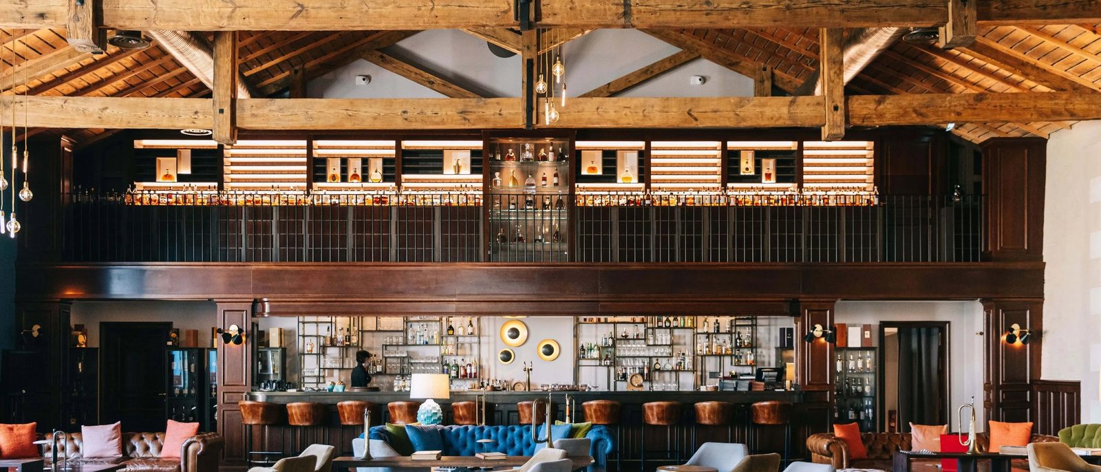 Le Bar 1838 de l'Hôtel Chais Monnet, dans l'ancienne tonnellerie, sous sa charpente de bois et sa mezzanine