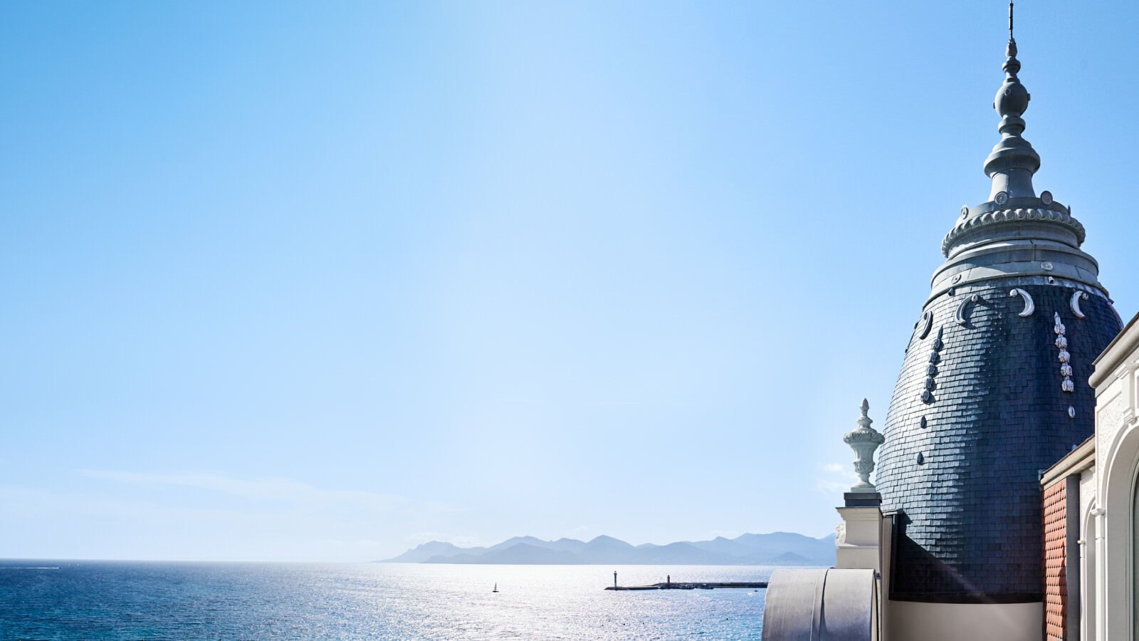 La coupole d'ardoise du Carlton Cannes, la baie de Cannes et les massifs de l'Estérel au fond