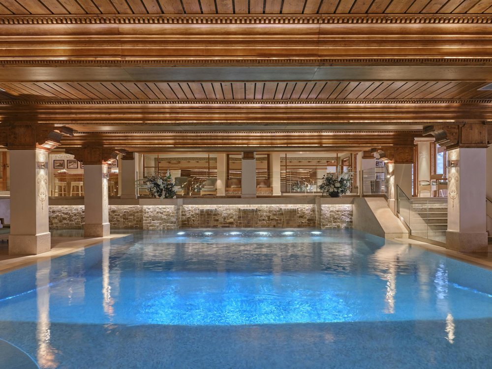 La piscine du spa des Airelles, sous son plafond de bois sculpté et ses colonnes