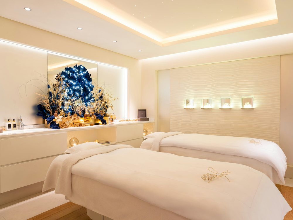 La cabine duo du spa Guerlain du Cheval Blanc Courchevel, ses deux lits de soin et ses bouquets bleus