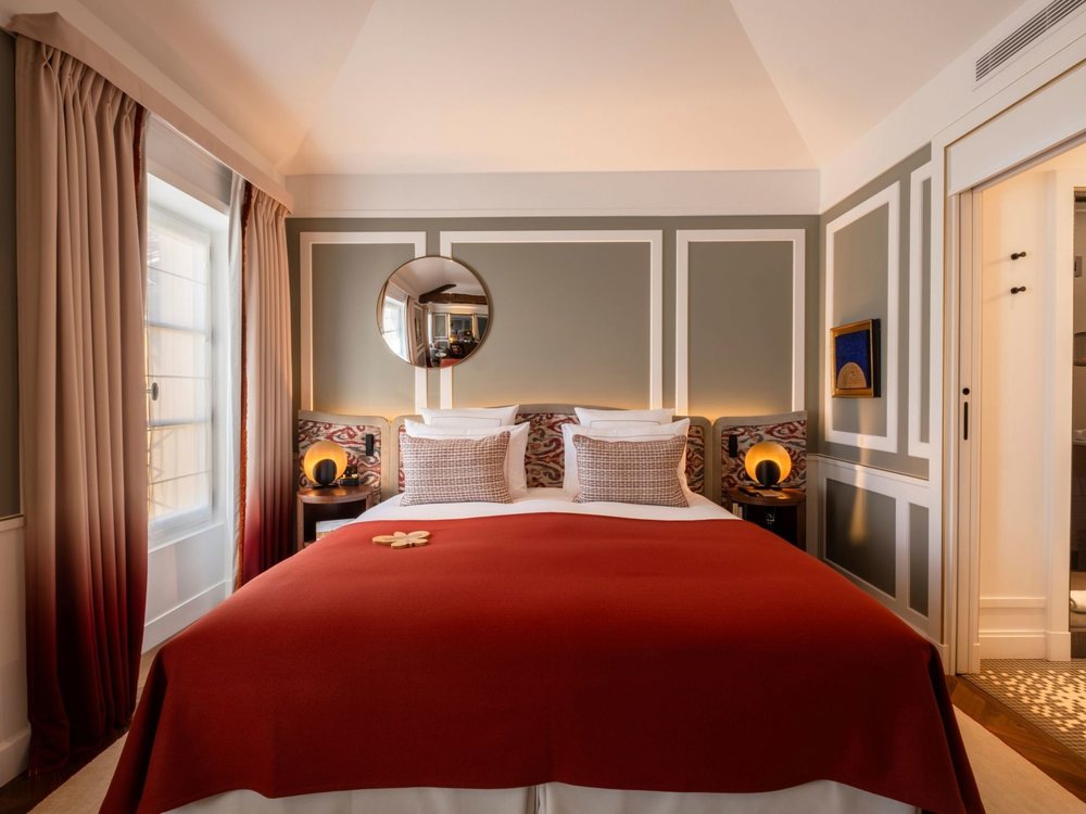 Une chambre des Lumières, à Versailles, ses boiseries grises, son lit au jeté rouge et son miroir rond