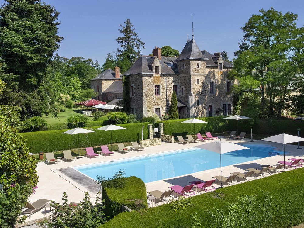Le château de la Bretesche et sa piscine, entourés de haies et de grands arbres