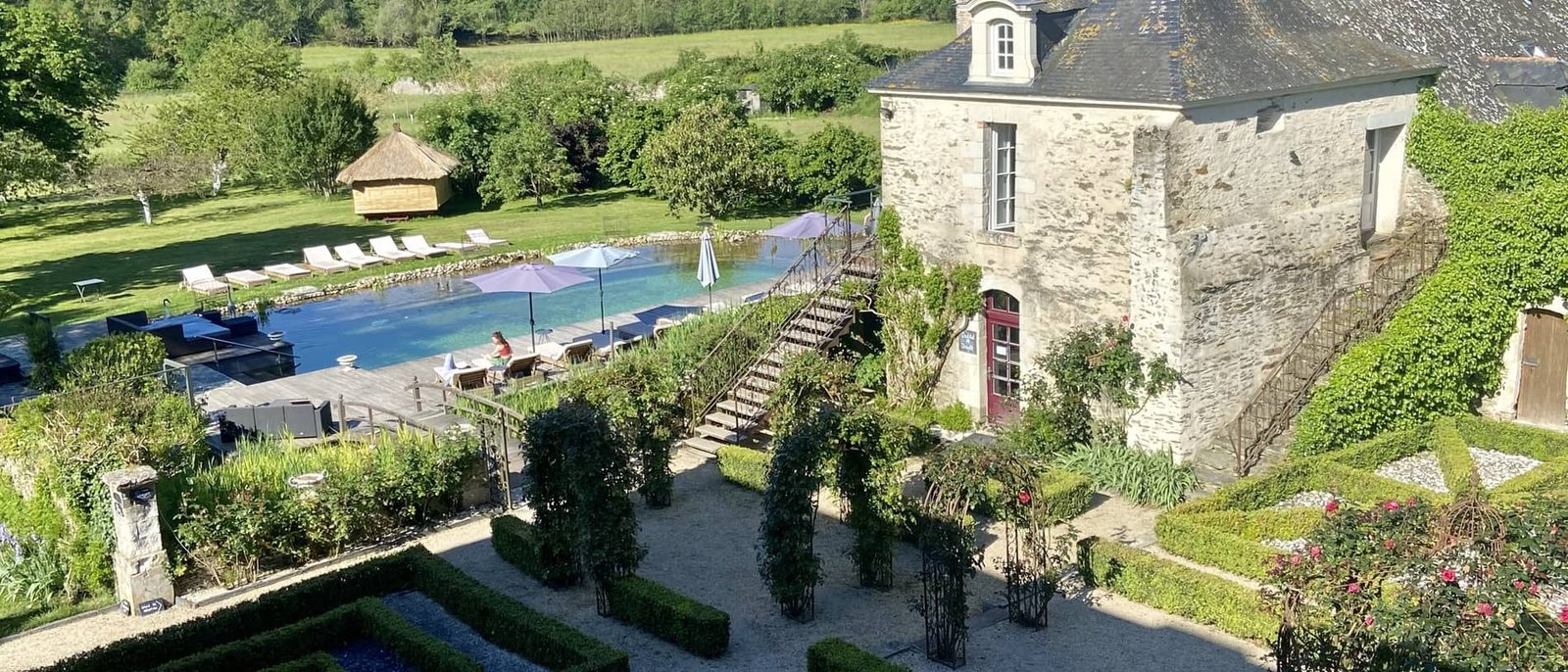 Le jardin à la française, la piscine et le logis du Château de l'Épinay, au milieu de la campagne angevine