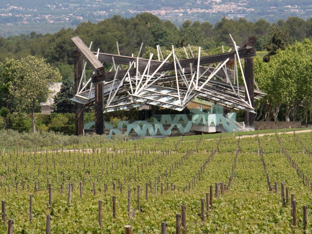 Les vignes du Château La Coste devant un pavillon d'art contemporain, sous les collines provençales