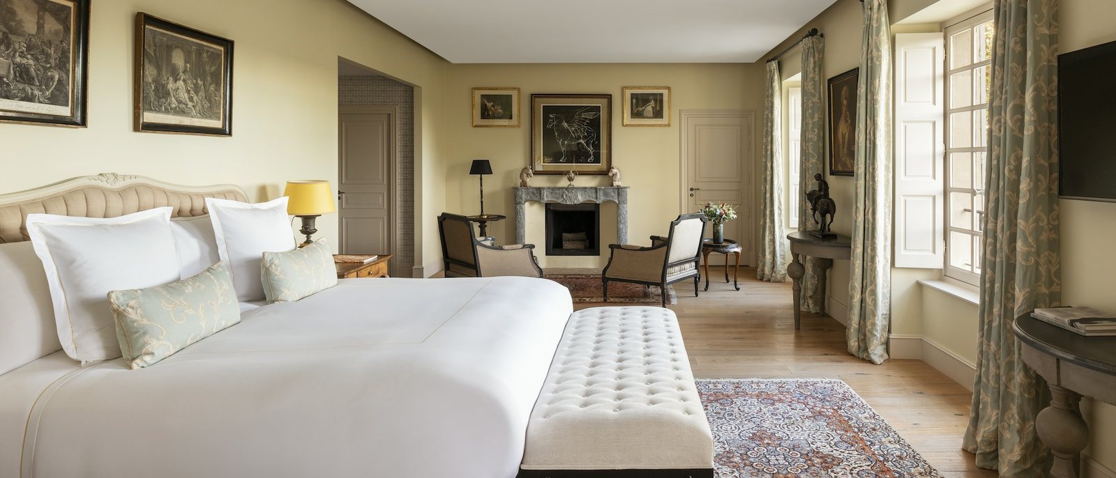 La chambre La Cavalière du Château d'Estoublon, sa banquette capitonnée et sa cheminée