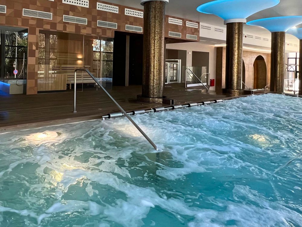 Un bassin à jets de l'Aquatherma de Lanjarón, sous des arches et un plafond éclairé de bleu