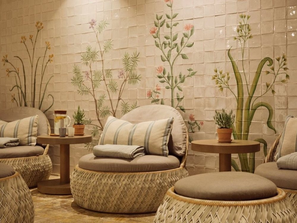 Le salon du Herbal Spa du Marbella Club, ses fauteuils tressés et ses murs peints de plantes