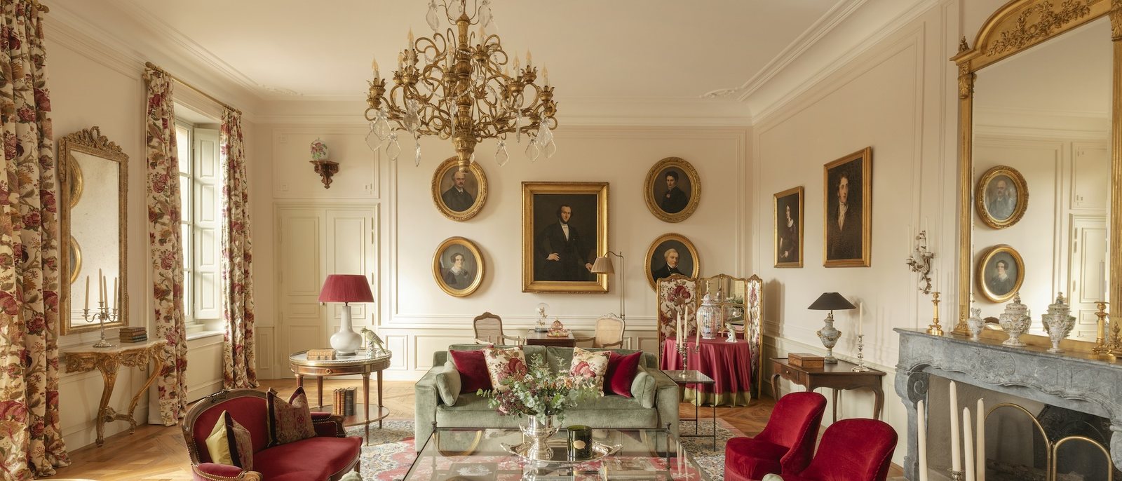 Le salon d'honneur du Château d'Estoublon, son lustre, ses portraits et ses fauteuils rouges