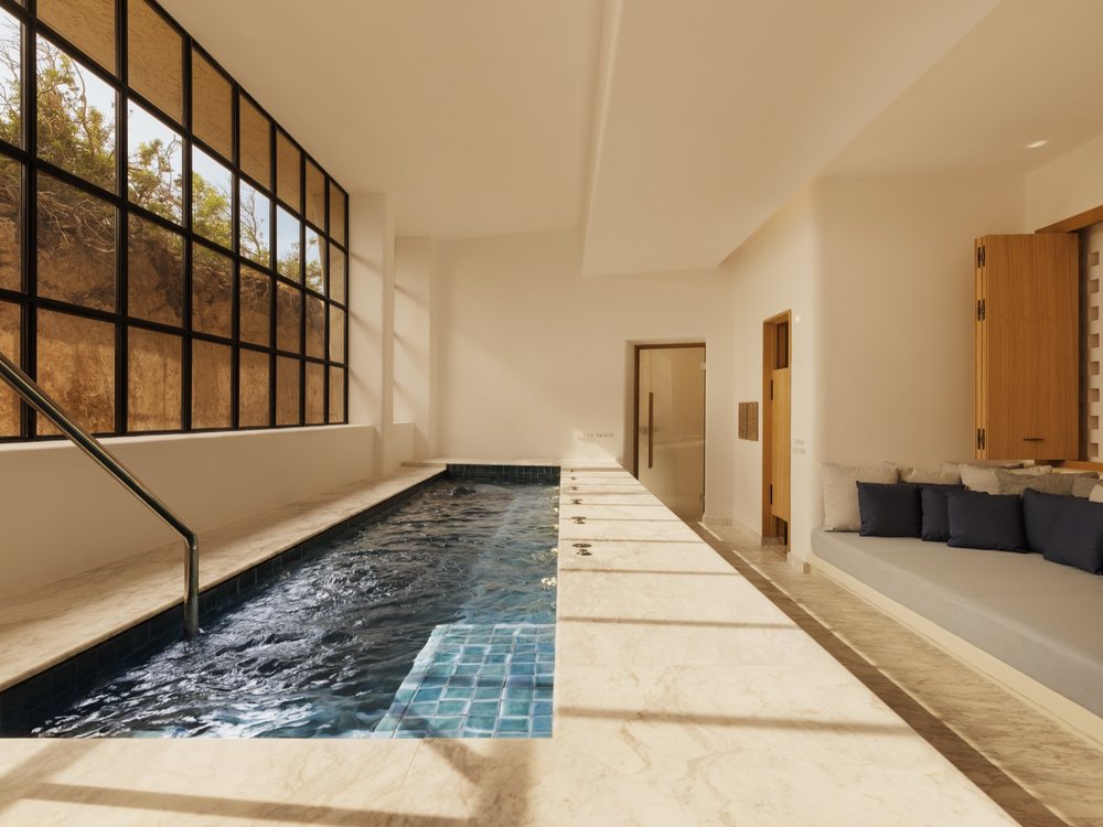 Le bassin intérieur du spa de Six Senses Ibiza, long et étroit, sous une verrière ouverte sur la végétation