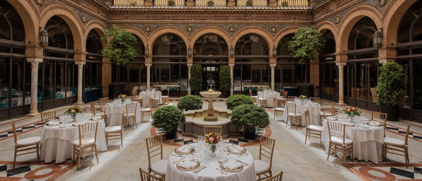 Le patio de l'Hotel Alfonso XIII, à Séville, dressé pour une réception autour de sa fontaine, sous les arcades
