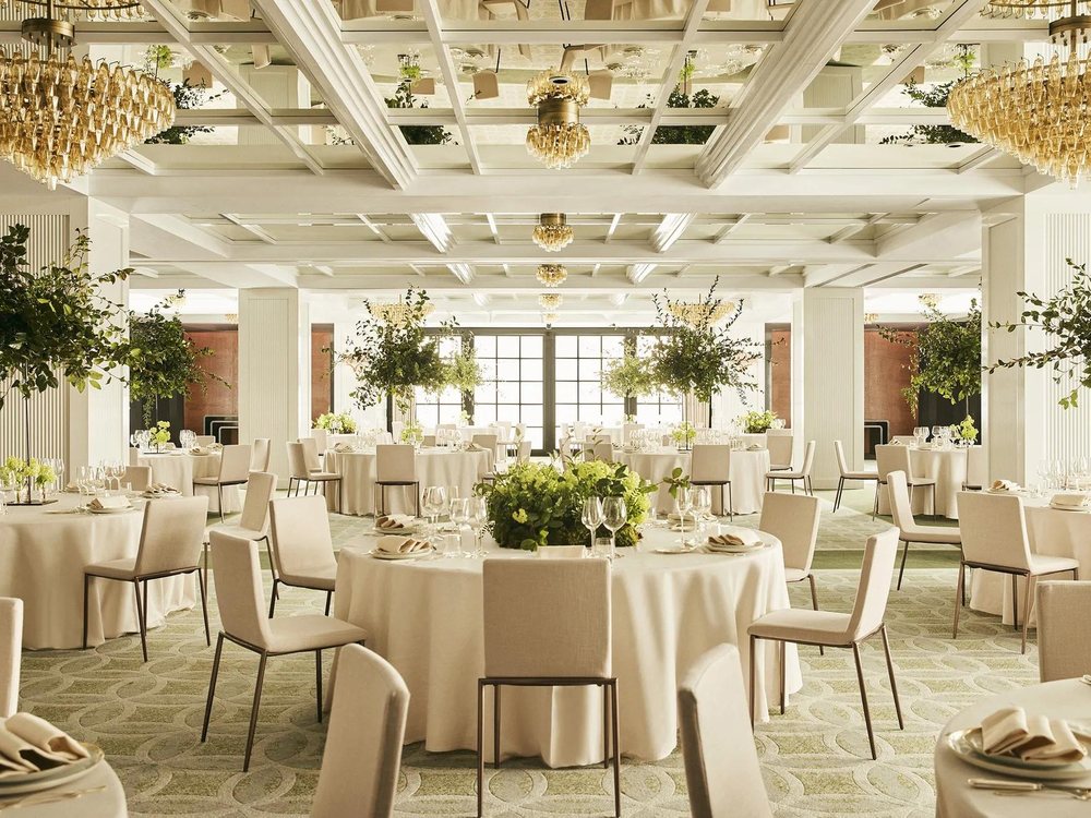 La salle de bal du Rosewood Villa Magna dressée en tables rondes, lustres et arbres en pot