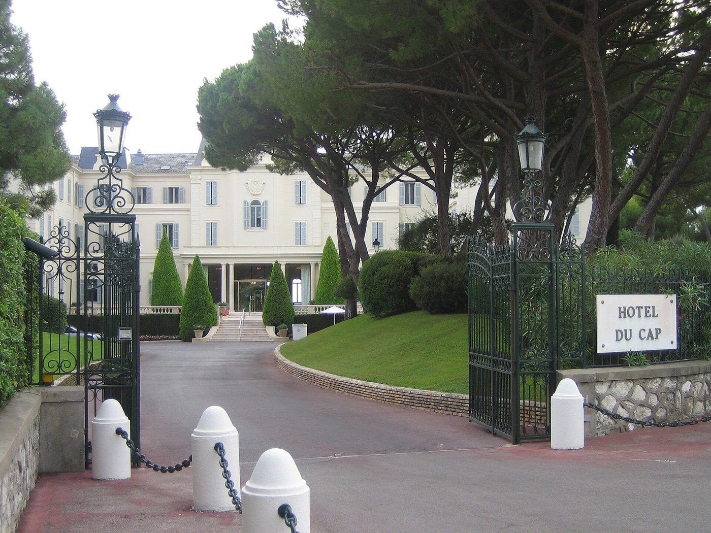 La grille d'entrée et la façade blanche de l'Hôtel du Cap-Eden-Roc, sur le cap d'Antibes