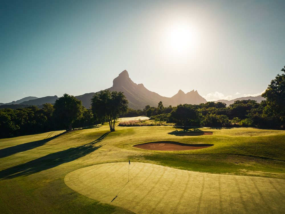 Un green du Tamarina Golf Club en contre-jour, la montagne du Rempart au fond