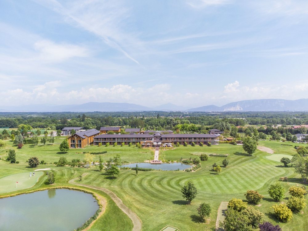 Vue aérienne du Jiva Hill Resort, de son golf et de ses plans d'eau, face aux montagnes