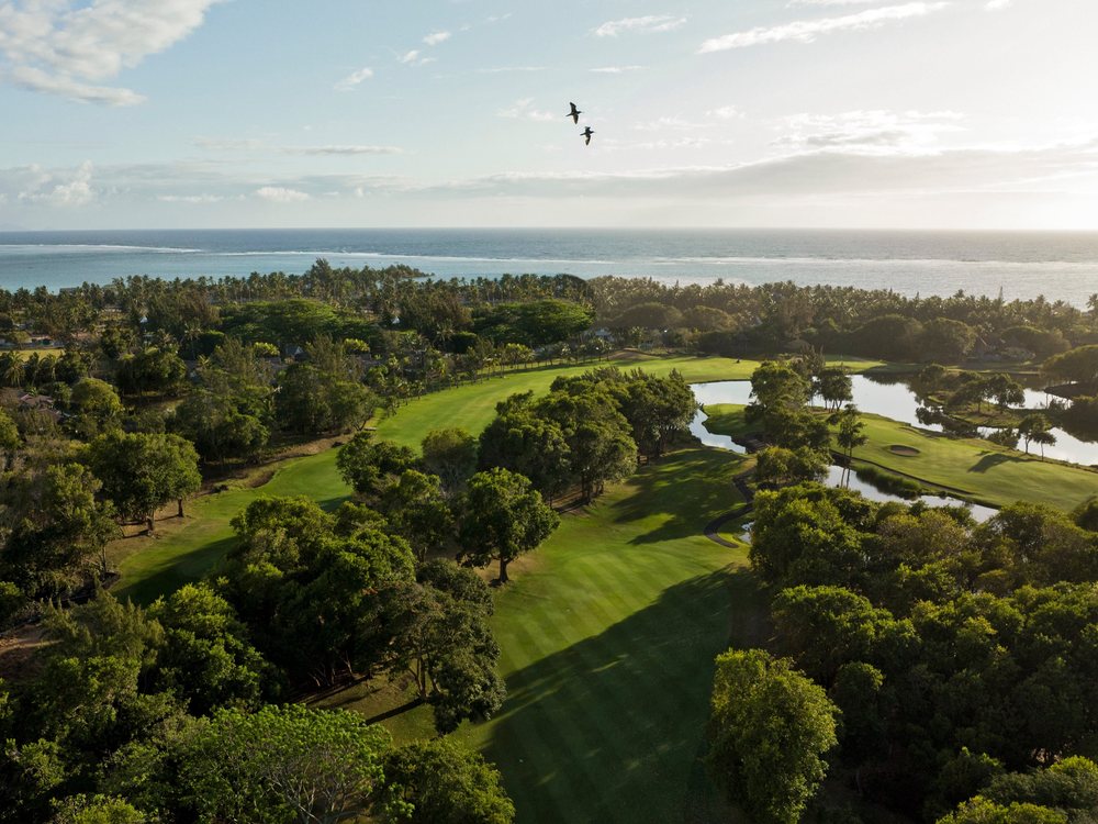 Le Legend Golf Course vu du ciel au matin : fairway dans la forêt, lacs et océan à l'horizon