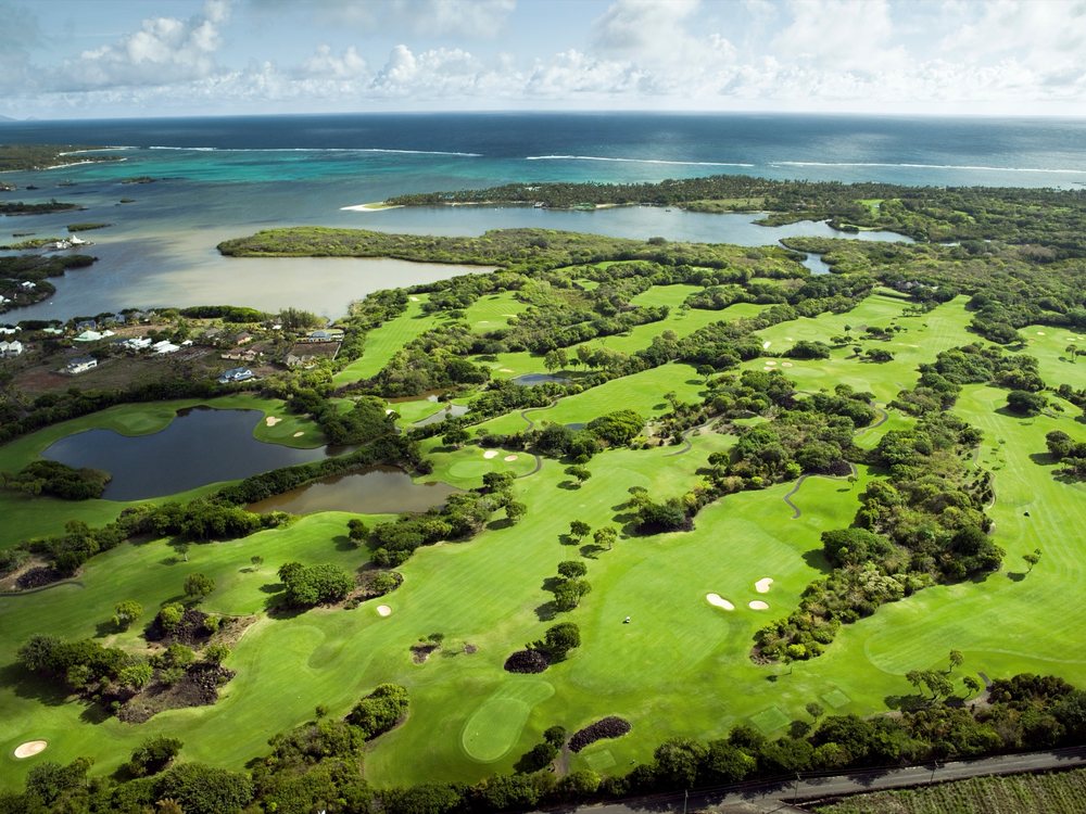 Le Links Golf Course vu du ciel : fairways entre roches volcaniques et bosquets, lagon et récif au loin