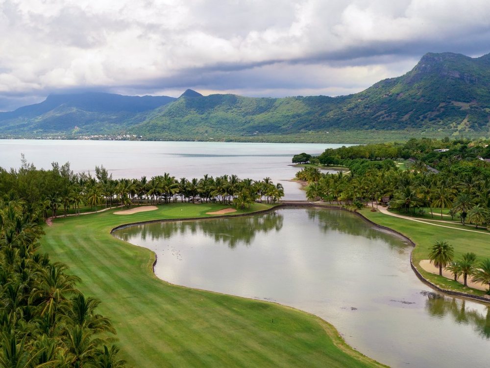 Un fairway et un plan d'eau du Paradis Golf Club, entre le lagon et les montagnes du Morne
