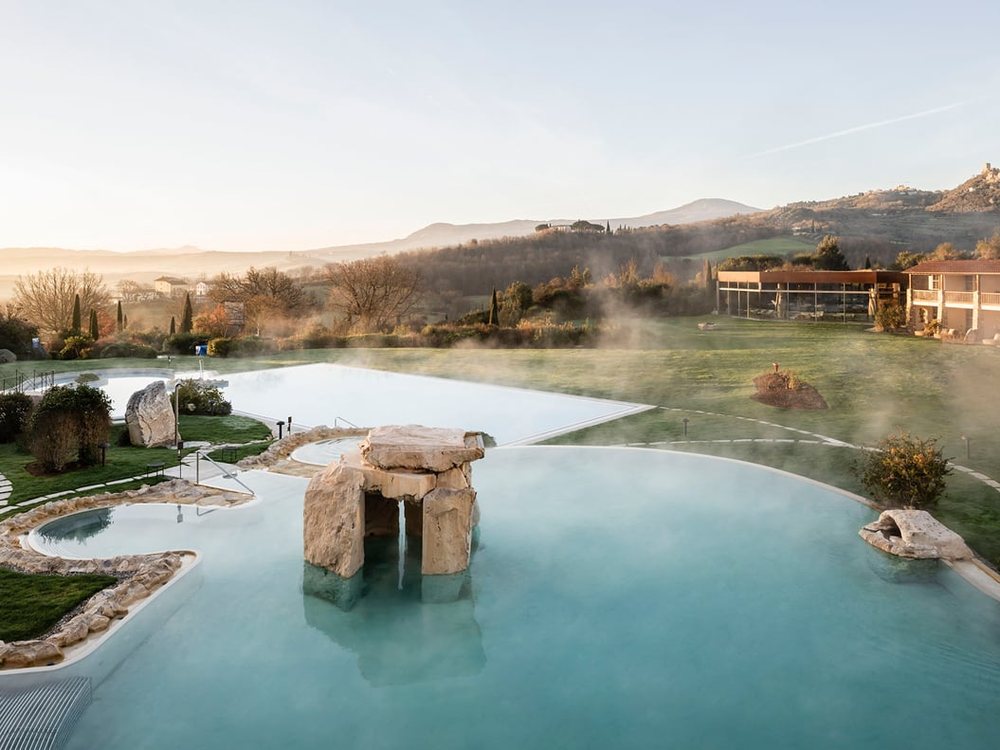 Les bassins thermaux extérieurs de l'ADLER Thermae dans la vapeur du matin, face à la campagne du Val d'Orcia