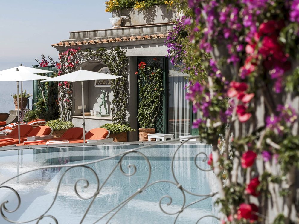 La piscine du San Pietro di Positano, ses parasols et ses bougainvilliers, sur les terrasses de la falaise