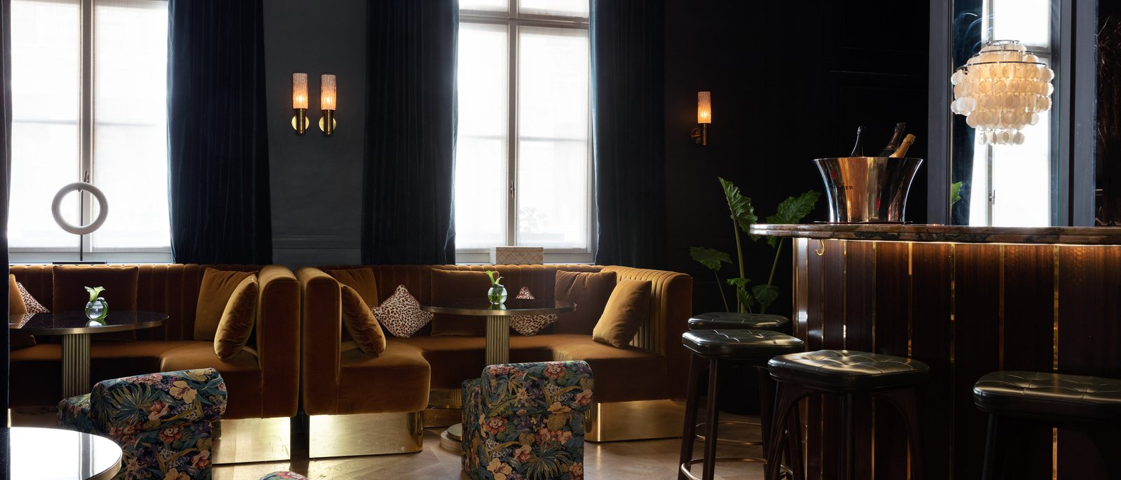 Le bar The Confidential des Jardins du Faubourg, ses banquettes de velours, ses fauteuils fleuris et son comptoir