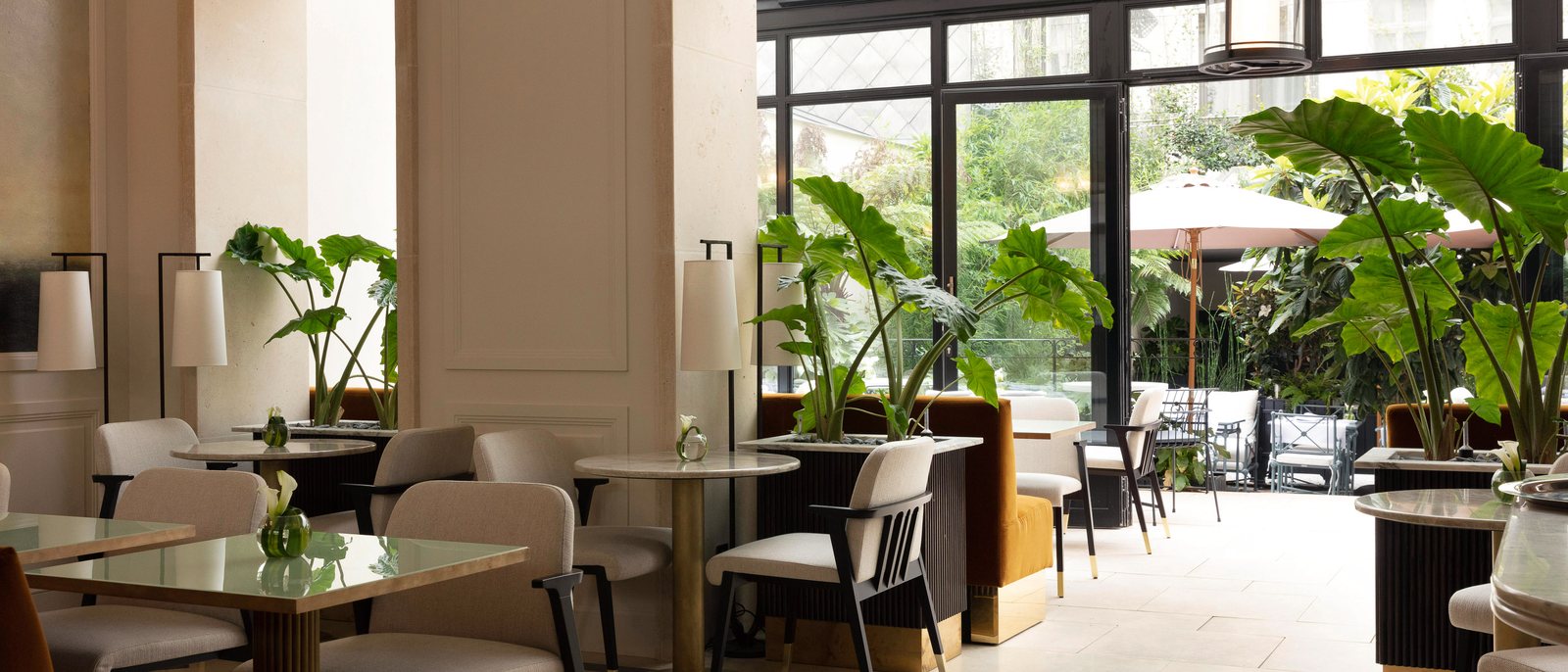 Le jardin d'hiver d'Il Giardino, sous la verrière des Jardins du Faubourg, avec ses tables de marbre et ses plantes
