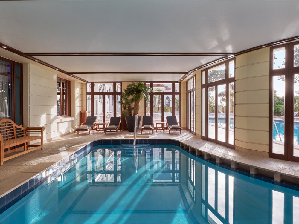 La piscine intérieure du spa de L'Hermitage à La Baule, chauffée à 28 °C, ses transats et ses grandes baies