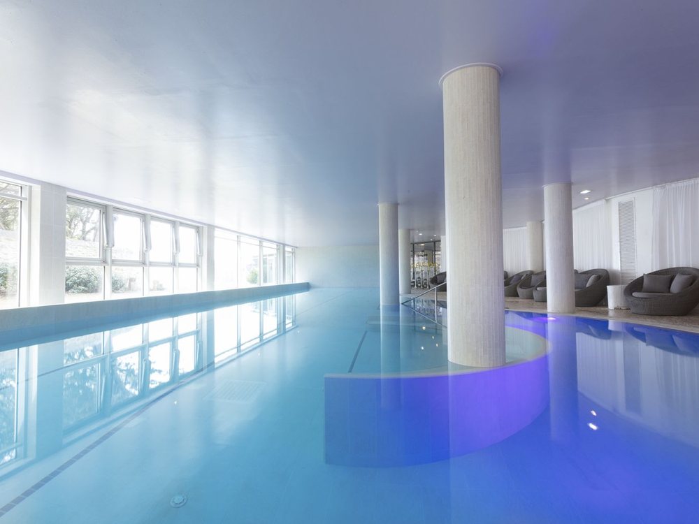 La piscine d'eau de mer du Relais Thalasso Château des Tourelles, son long bassin bleu, ses colonnes et sa verrière