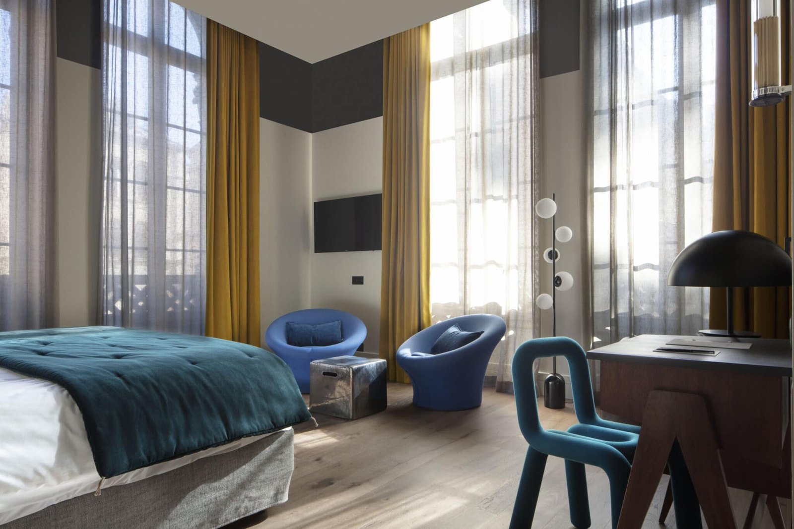 Chambre de l'Hôtel de l'Abbaye à Lyon, hautes fenêtres, rideaux jaunes et fauteuils bleus