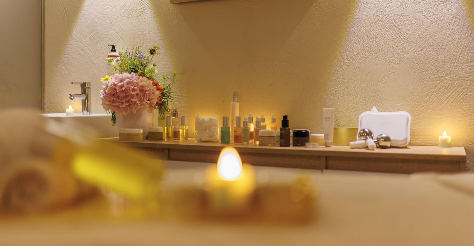 Table de soins, bougies et flacons dans une cabine du spa du Boscolo Lyon