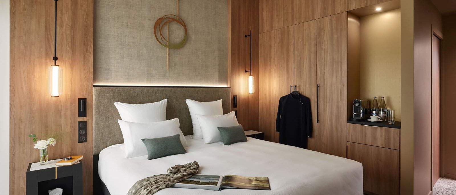 Une chambre du Domaine du Liziec, sa tête de lit et sa couronne dorée suspendue