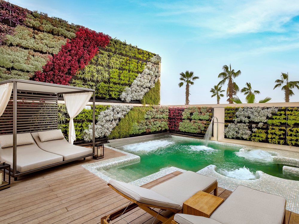 Le bassin de relaxation en terrasse du spa du Conrad Rabat Arzana, ses transats et son mur végétal