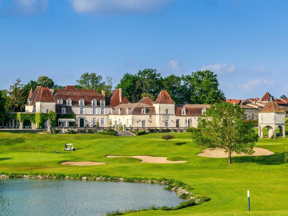 Le Château des Vigiers et ses dépendances au-dessus du golf et d'un étang, en Dordogne