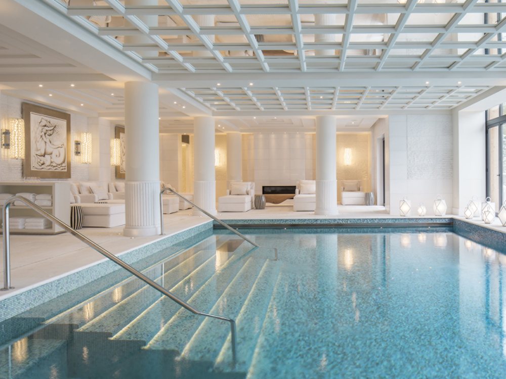 La piscine intérieure du Four Seasons Resort Megève, entre ses colonnes blanches et sa verrière