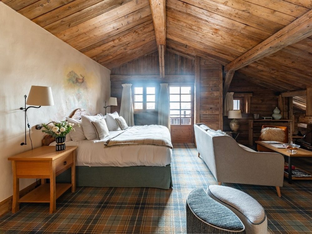 Une chambre mansardée des Chalets du Mont d'Arbois, charpente de bois et moquette écossaise