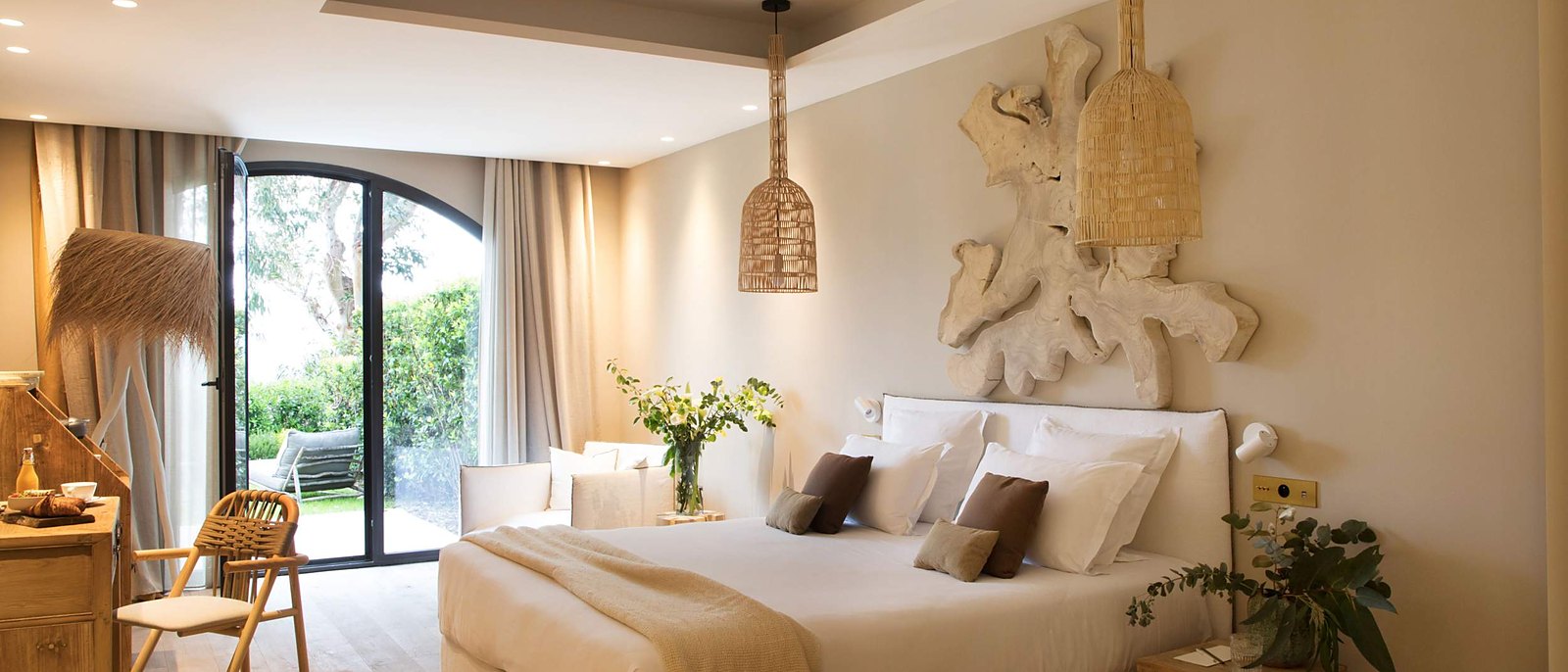 Une chambre du Domaine de Misíncu, sa tête de lit sculptée et ses portes sur le jardin