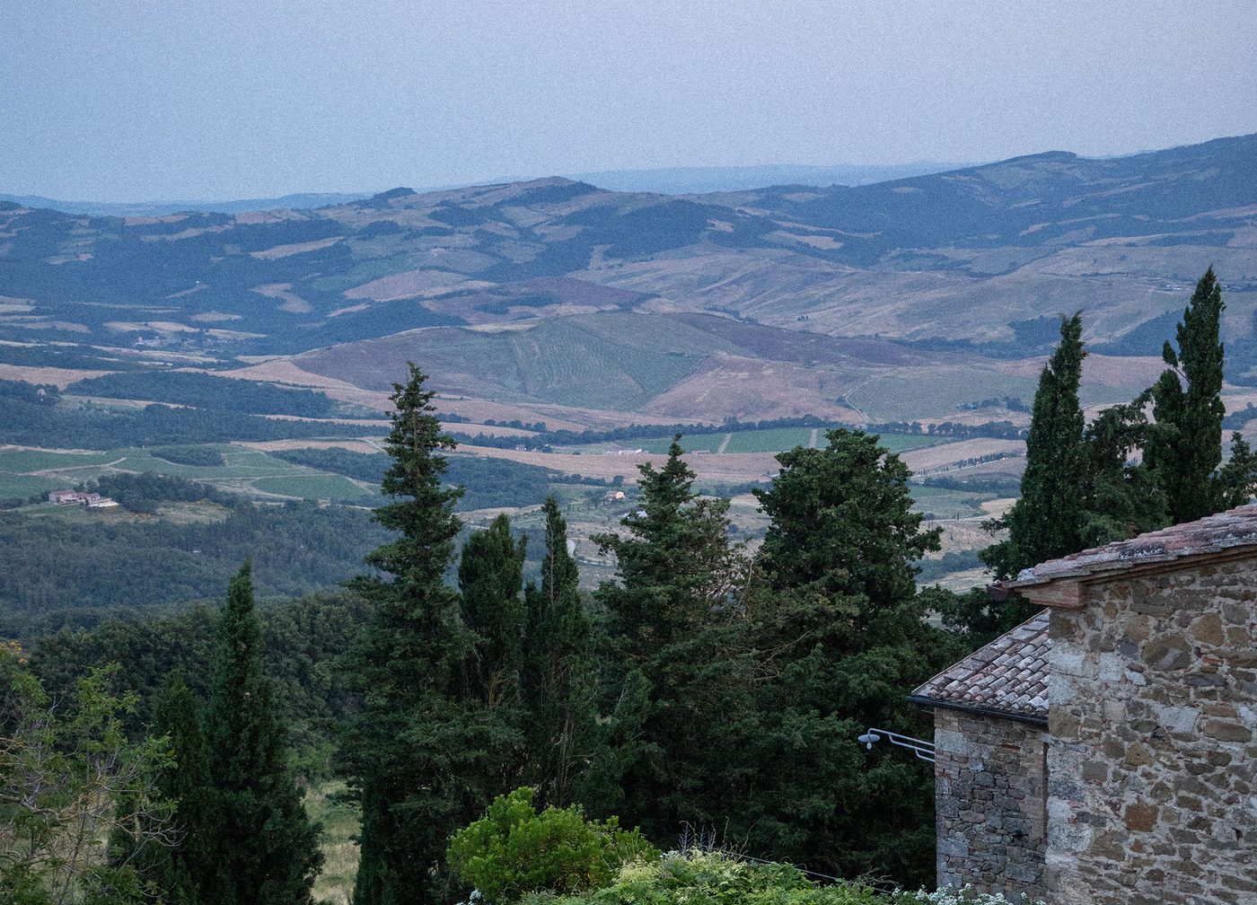 Dîner sous la pergola de Monteverdi Tuscany, au crépuscule, au-dessus des collines du Val d'Orcia